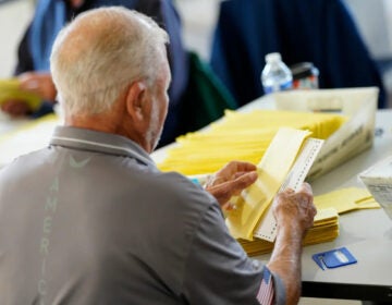 A person puts a ballot in an envelope