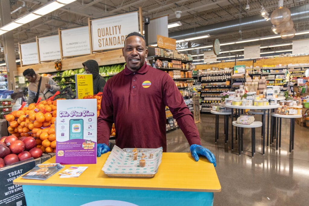 Ronnie McDaniels, regional manager of PLNT burger in Pa., hands out samples of Lil’ Dippers at the Whole Foods attached to the restaurant’s Wynnewood location. (Kimberly Paynter/WHYY)