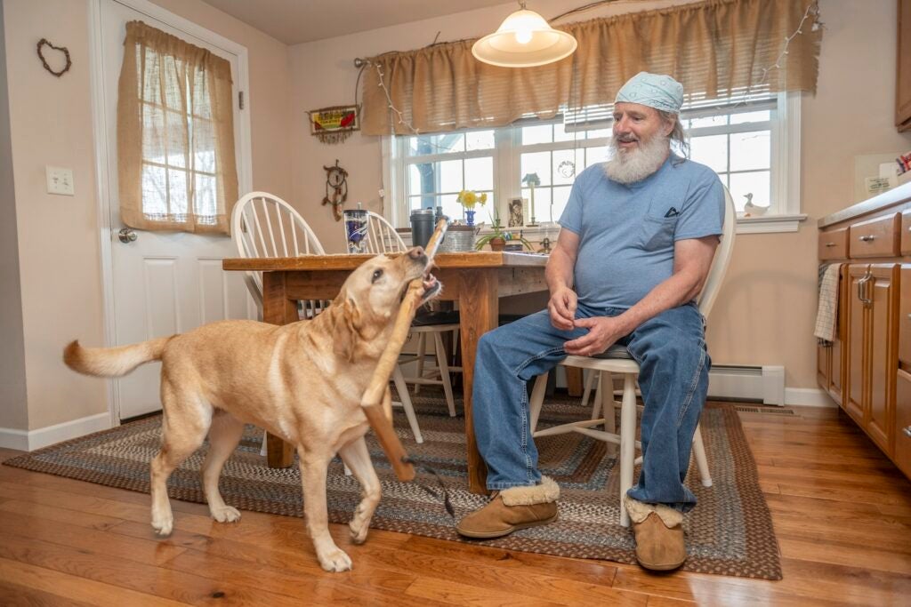 Trained service dog Harper brings owner Gary his cane.