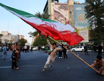 Demonstrators wave a huge Iranian flag in Tehran