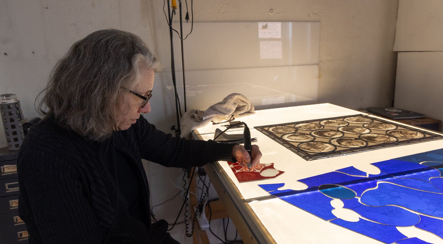 Judith Schaechter engraves a piece of glass