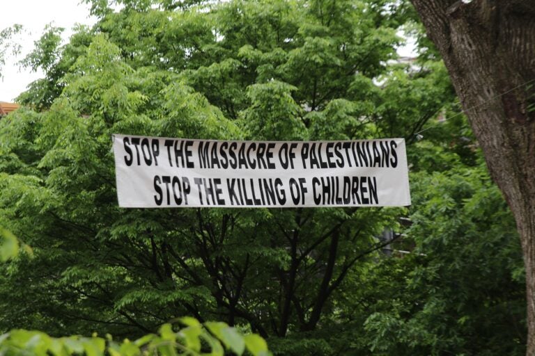 a sign reads stop the massacre of Palestinians stop the killing of children