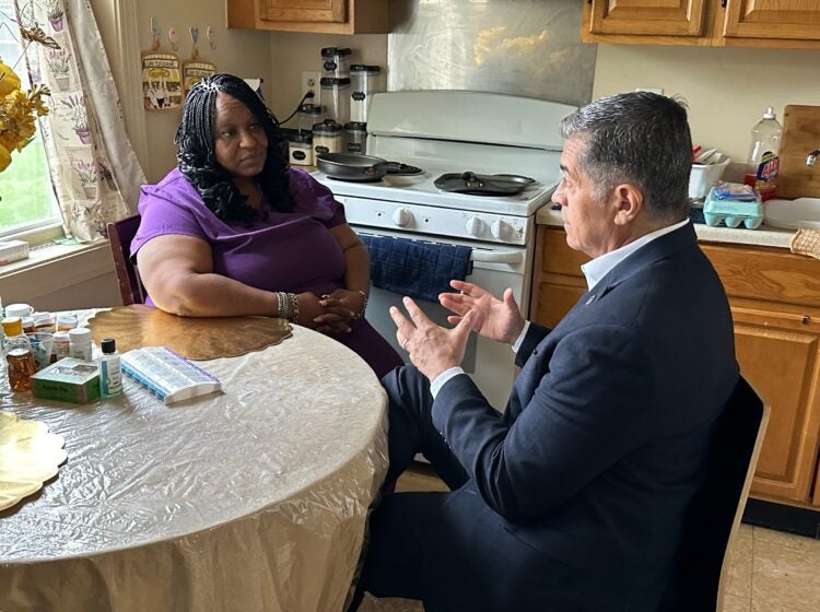 Xavier Becerra and Lolita Owens sit at a kitchen table