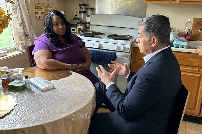 Xavier Becerra and Lolita Owens sit at a kitchen table