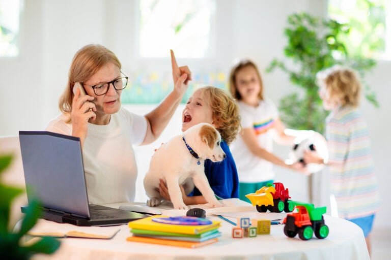 Mother working from home with kids.(Bigstock/famveldman)