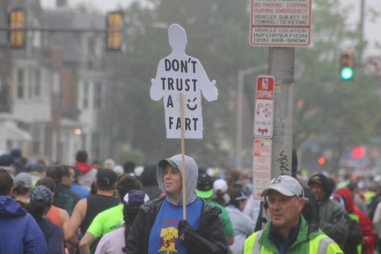 a supporter holds a sign reading don't trust a fart