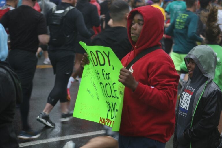 a supporter watches the runners