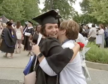 a graduate hugs a woman at graduation