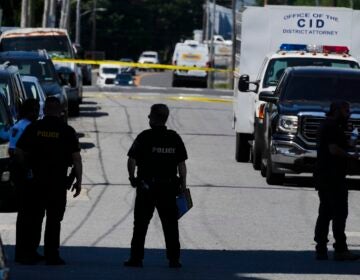Law enforcement stand at the scene of a fatal shooting at Delaware County Linen, Wednesday, May 22, 2024, in Chester, Pa.