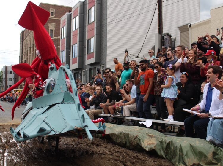 Tony Bolante appears in costume as a giant squid in the mud pit at the 2024 Kensington Derby and Arts Festival