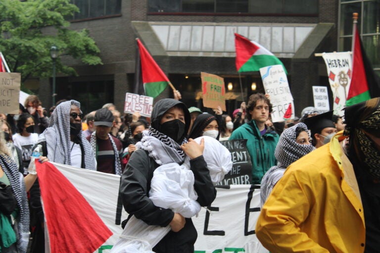 Hundreds of pro-Palestinian protesters marched from City Hall toward University City on Saturday. They linked arms and encircled a group of people setting up tents on Drexel University's campus. (Emily Neil/WHYY News)