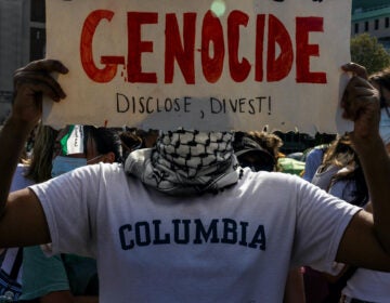 Protester holds a sign that says 'Genocide'