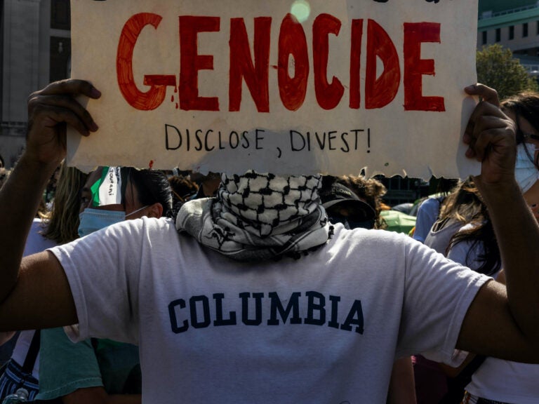 Protester holds a sign that says 'Genocide'