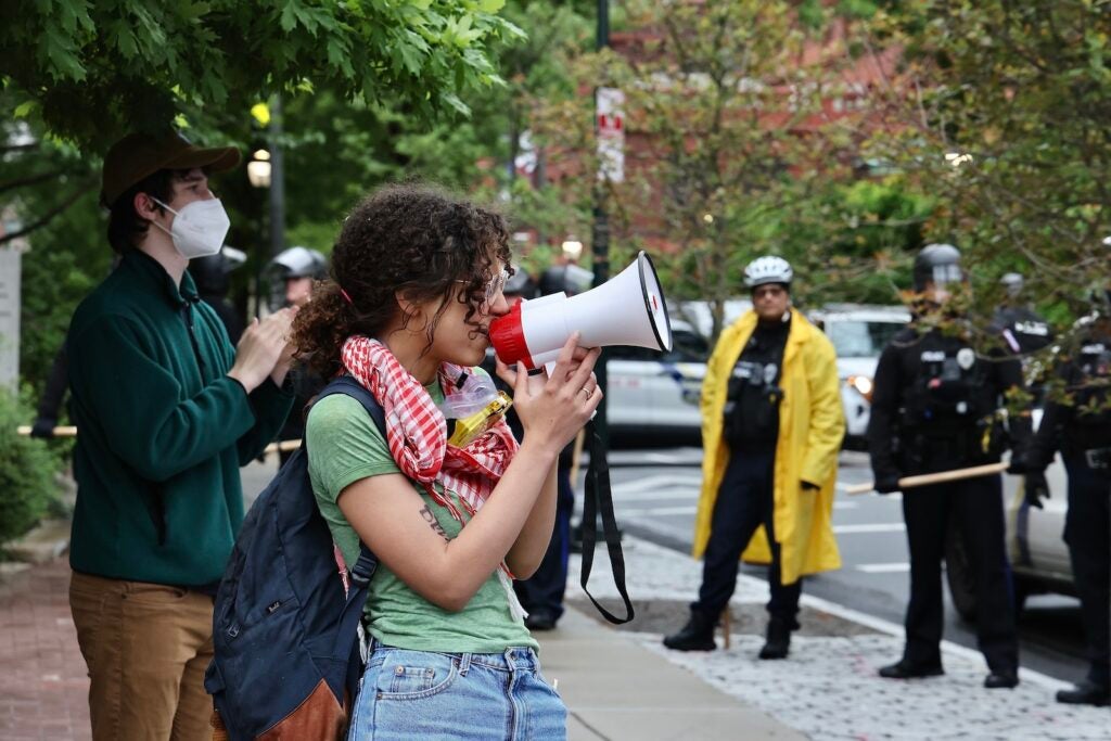 Penn graduate Zoe Sturges leads a protest chant as police clear the encampment on College Green.