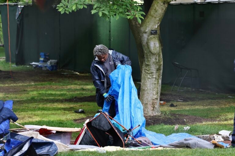 A worker clears away a tent on Penn’s college green.