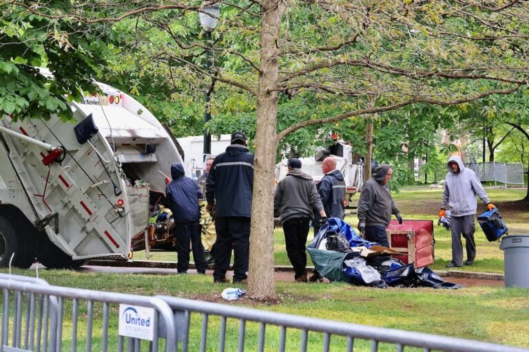 Workers load protesters tents and possessions into a garbage truck after clearing the the protest encampment on Penn’s college green.