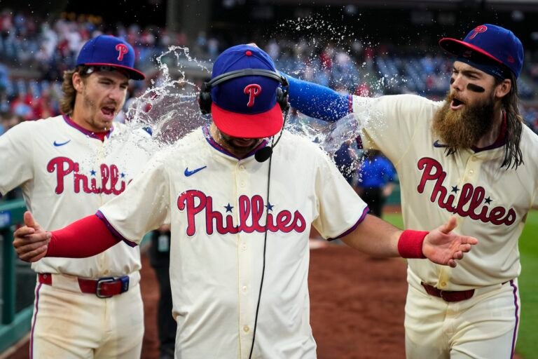 Philadelphia Phillies' Bryson Stott, left, and Brandon Marsh, right, dump water and candy on Whit Merrifield after winning against the San Francisco Giants, Monday, May 6, 2024, in Philadelphia