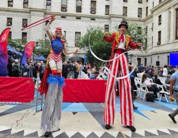 2 people dressed in costumes on stilts