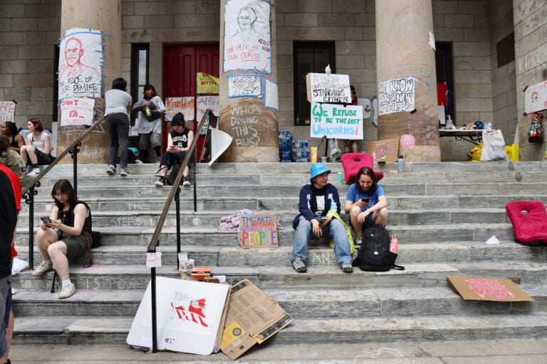 Students gather with signs on the steps of Hamilton Hall