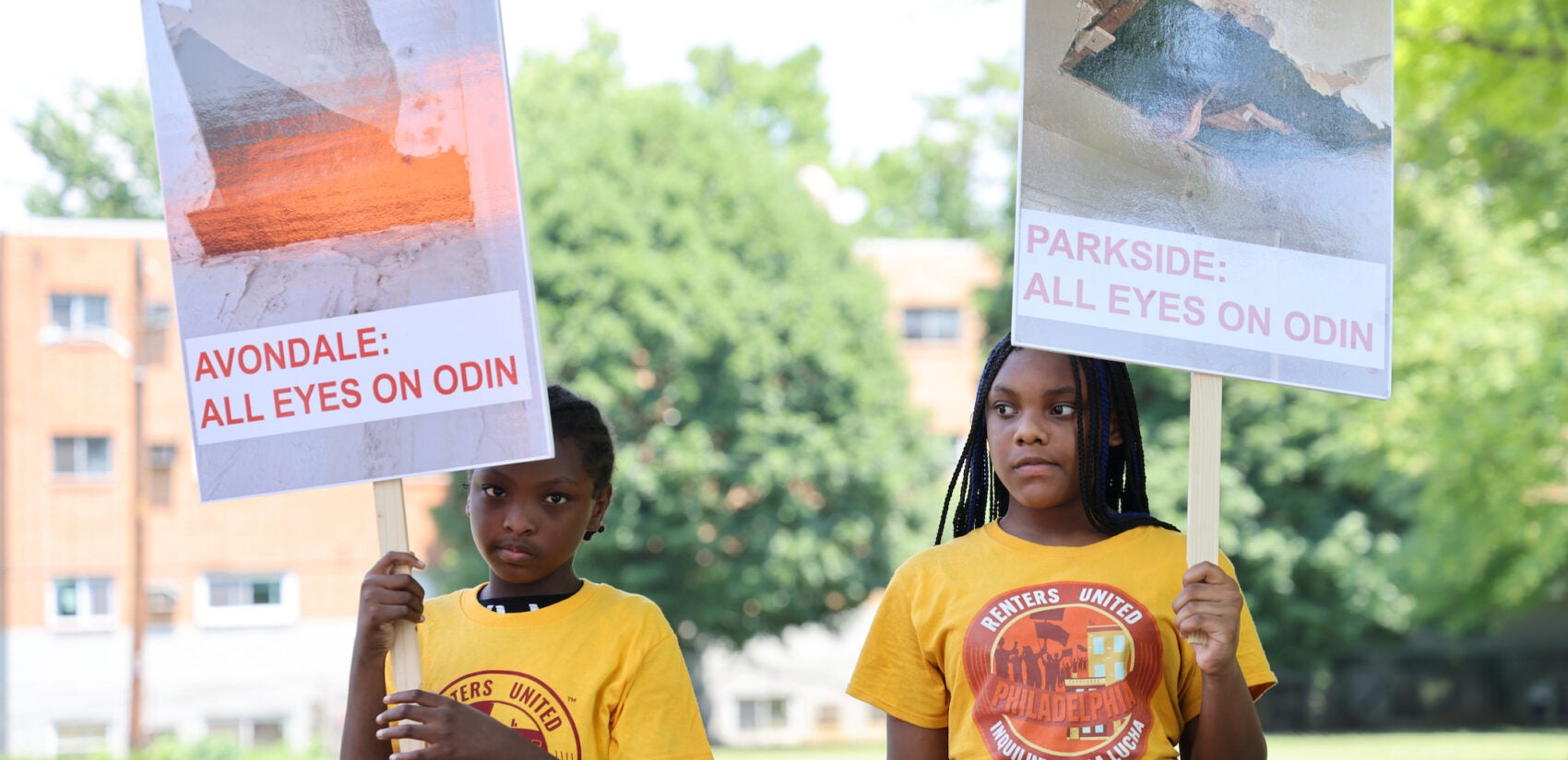 two children carry signs reading Avondale: All Eyes on Odin and Parkside: All Eyes on Odin