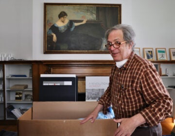 Sid Sachs packs up beneath a painting of Christine Wetherill Stevenson