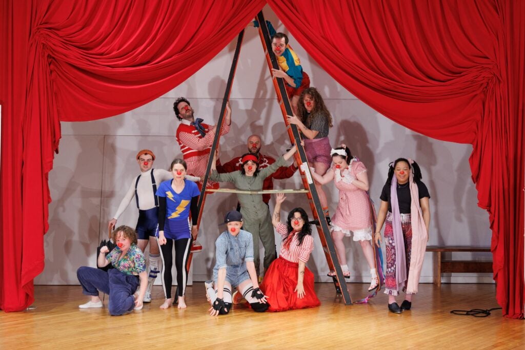 the cast of Pig Iron Advance Theater Training's 2024 Clowning Show onstage around and under a ladder