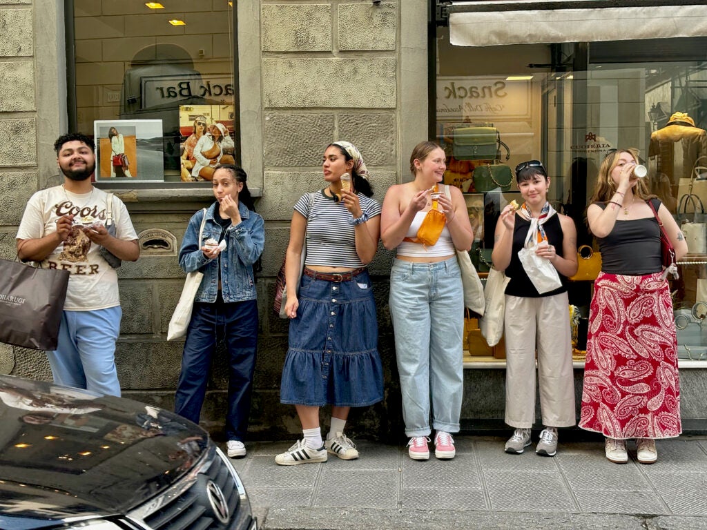 Students standing on the sidewalk eating gelato