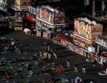 an aerial view of the site of a mass shooting shows turned over chairs and investigators working