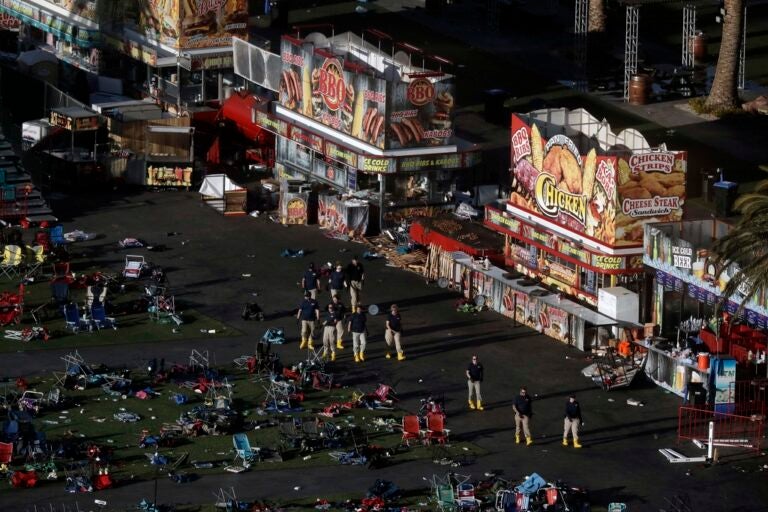an aerial view of the site of a mass shooting shows turned over chairs and investigators working