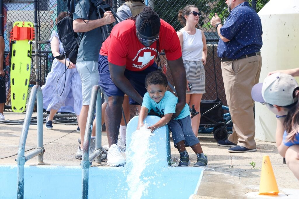 a lifeguard with a child at the pool