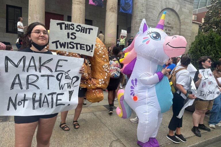 Students and a person dressed as a unicorn in front of the University of the Arts campus