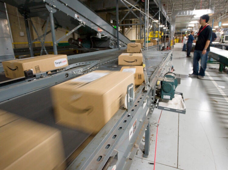 An Amazon.com employee watches boxes speed by on a conveyor belt at one of their warehouses. (AP file Photo/Scott Sady)