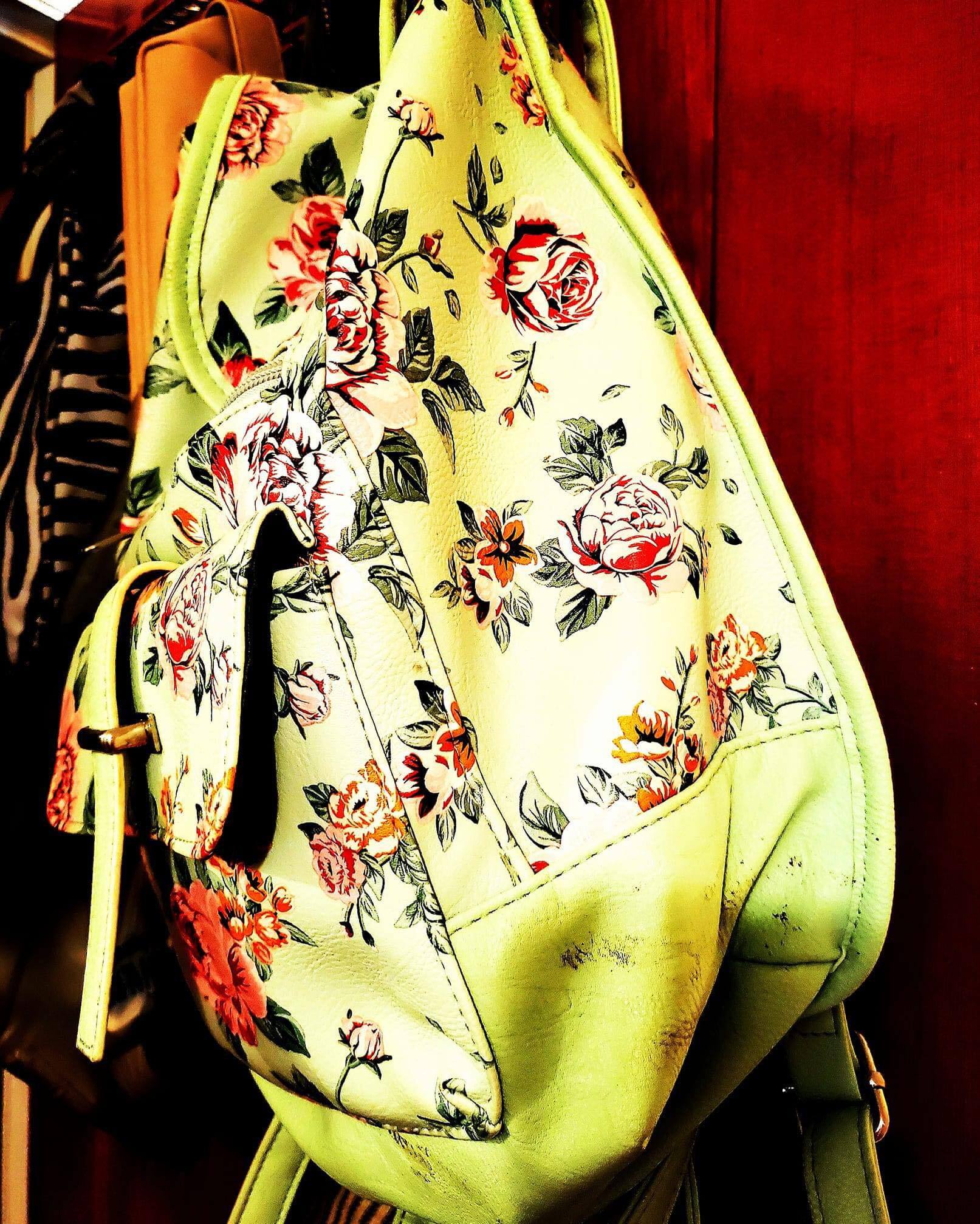 a white backpack with a design of roses