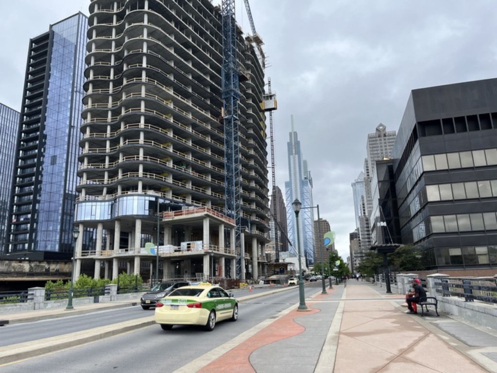 Taxi cab driving down the street in Philadelphia past an big construction project