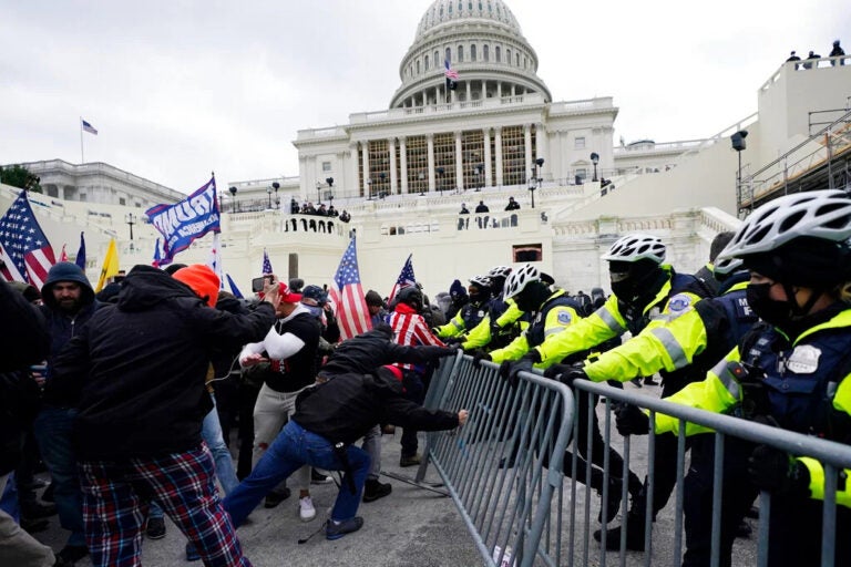 Insurrectionists try to break through a police barrier, Wednesday, Jan. 6, 2021, at the Capitol in Washington.