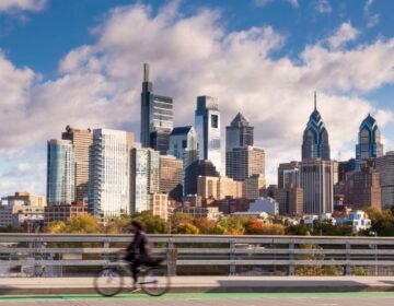 a person on a bike with the Philadelphia skyline behind them