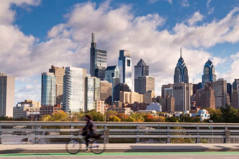 a person on a bike with the Philadelphia skyline behind them