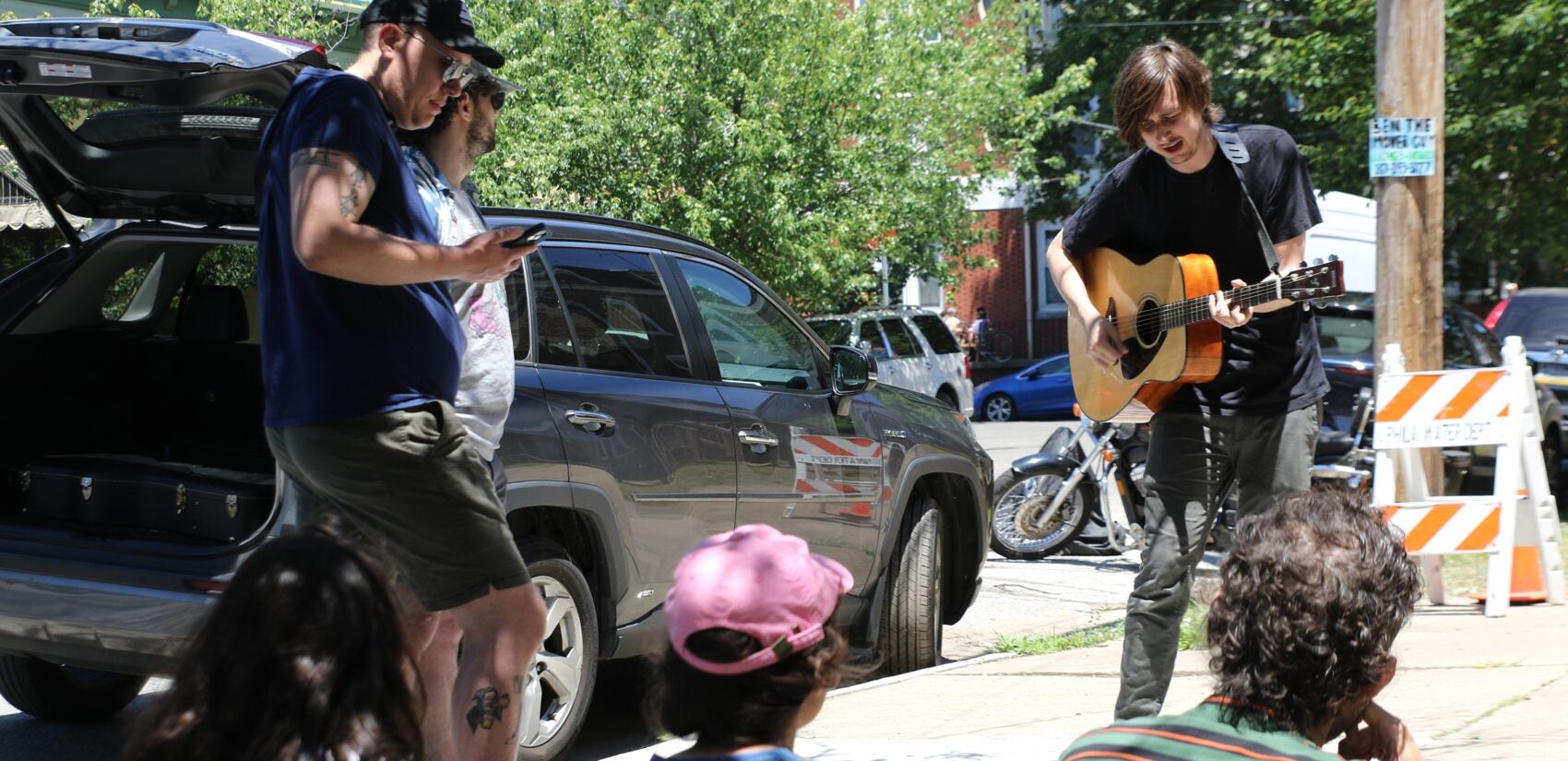 Porchfest attendees watch someone play guitar