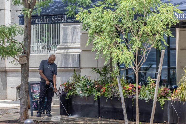 A man power washing the sidewalk