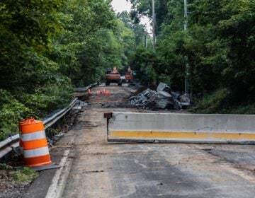 cones, bulldozers and barrier parts sit in an unused road