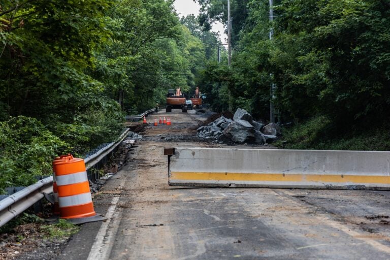 cones, bulldozers and barrier parts sit in an unused road