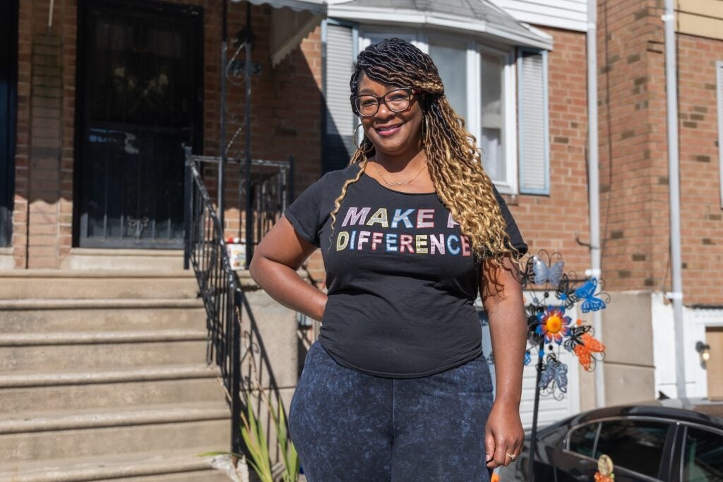 Jamie Glenn poses for a portrait on her street in Philadelphia's Eastwick neighborhood