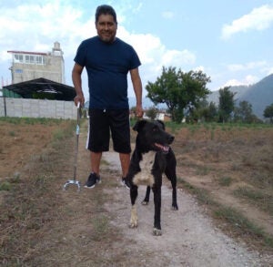 In one of Claudia’s favorite photos, her uncle walks in a field with his white-spotted dog. He holds his cane with a firm grip, smiling at Claudia from 2,000 miles away. (Courtesy of Claudia)