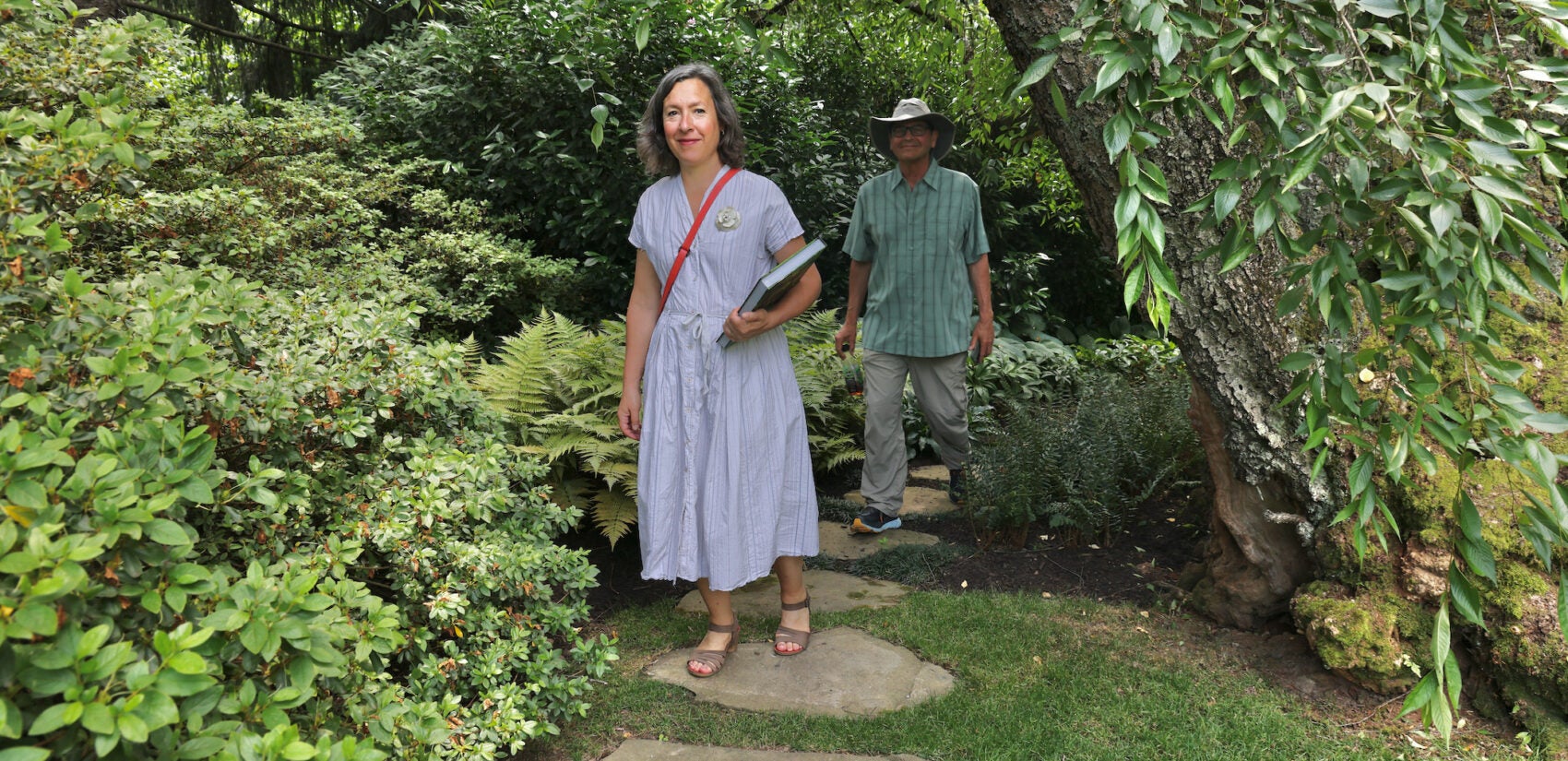 Author Nicole Juday and photographer Rob Cardillo walk through Leslie Miller's garden in Bryn Mawr.