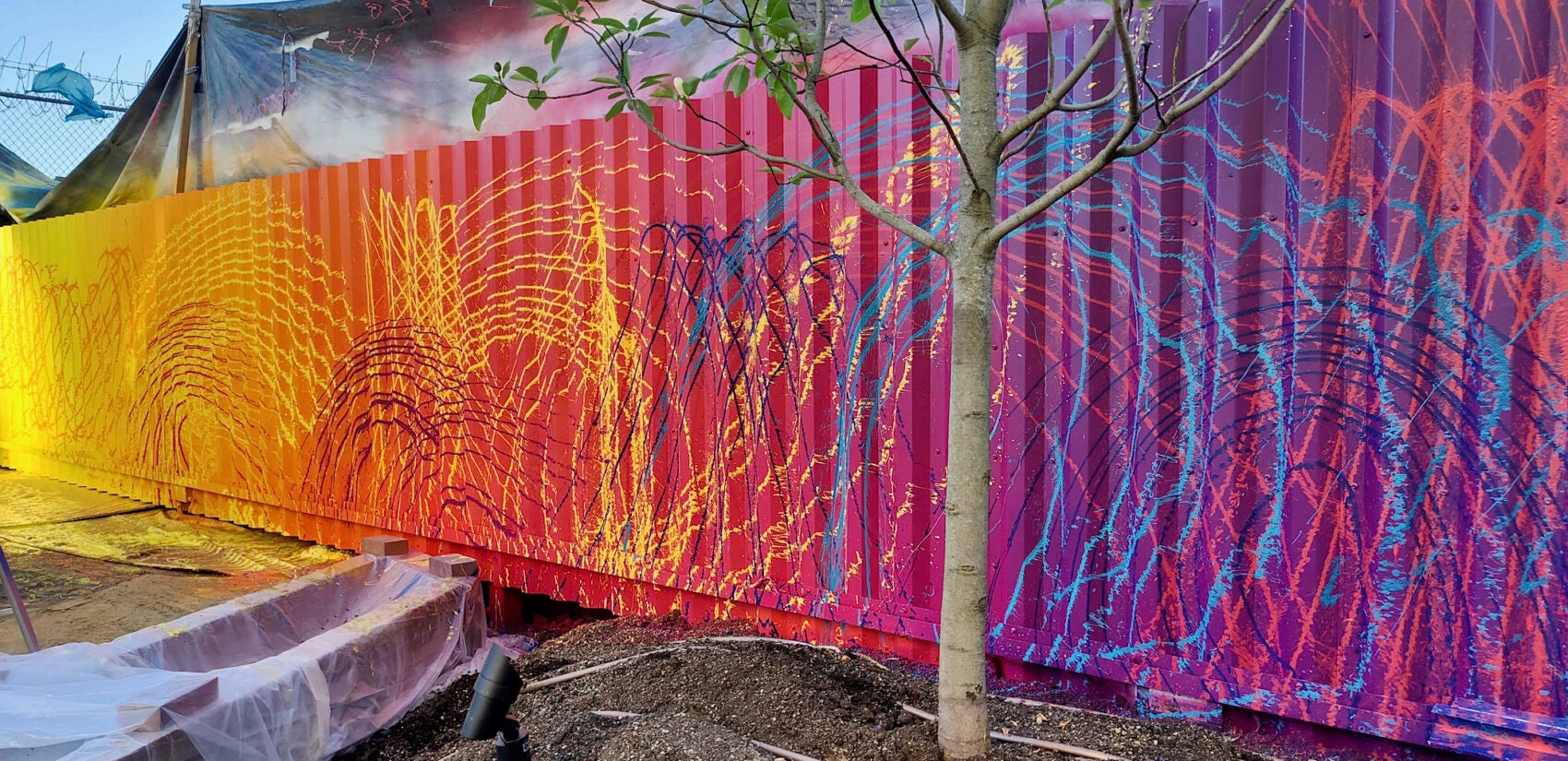 Artist Douglas Hoekzema, aka HOXXOH, created a rainbow-colored underlayer of color, on top of which he sprayed lines of complementary colors through garden hose attachments. (Peter Crimmins/WHYY)