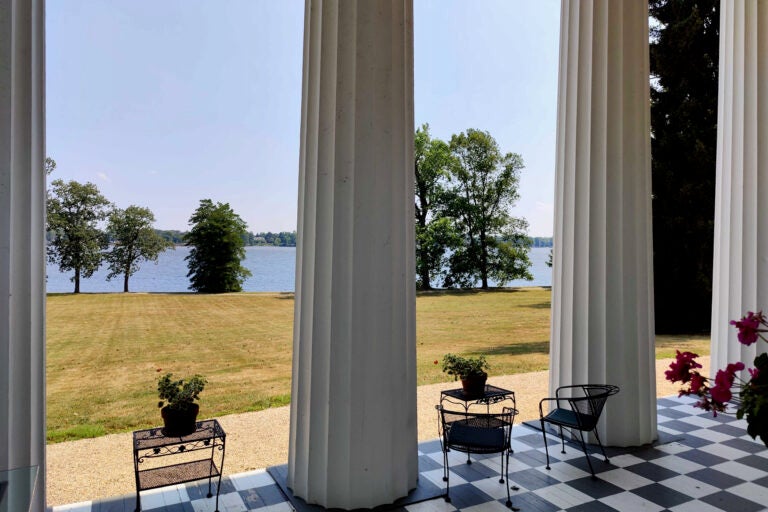 White columns stand in front of a waterfront view