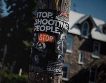 A “Stop. Shooting. People.” Poster by Philadelphia Ceasefire is posted in East Germantown in Philadelphia, PA.
(Hannah Yoon for NPR)