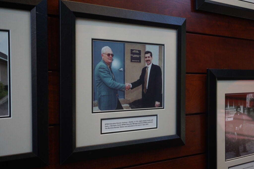 A photo of 2 men shaking hands hangs on the wall