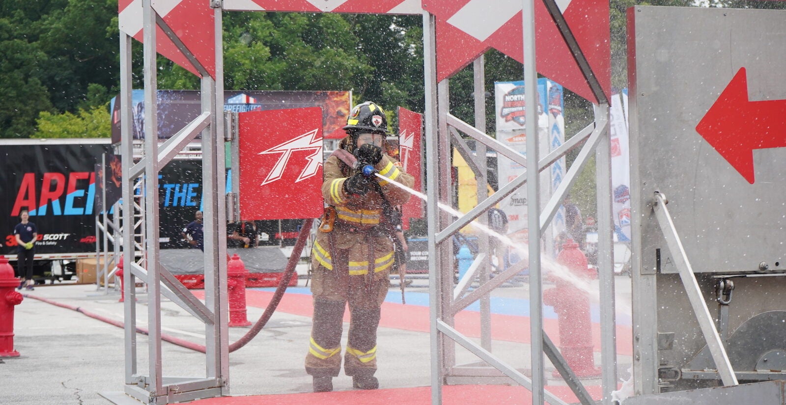 A firefighter holding a fire hose blasting out water
