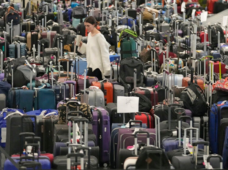 A woman walks through unclaimed bags at Southwest Airlines baggage claim at Salt Lake City International Airport on Dec. 29, 2022. (AP Photo/Rick Bowmer, File)